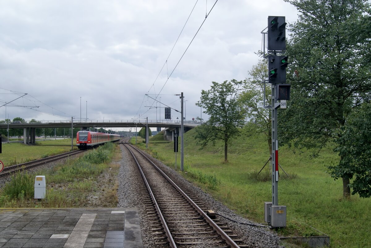 Eine Regionalbahn fährt unter einer Straßenbahnüberführung hindurch.